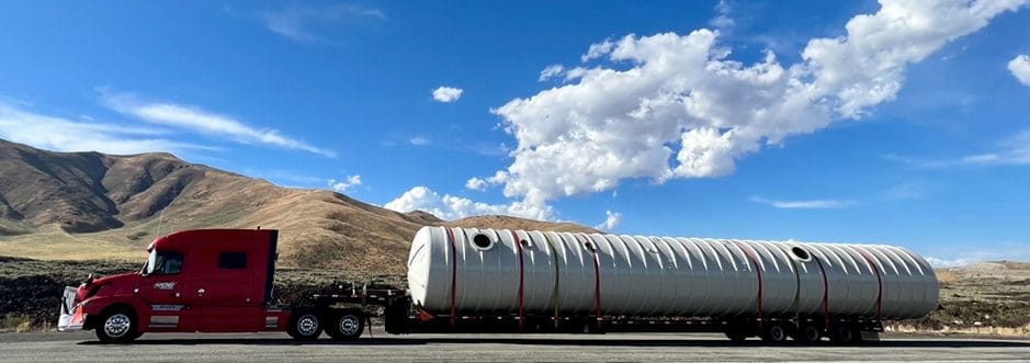 Underground storage tank on a red truck at Crater of the Moon National Park Space being taken to installation site