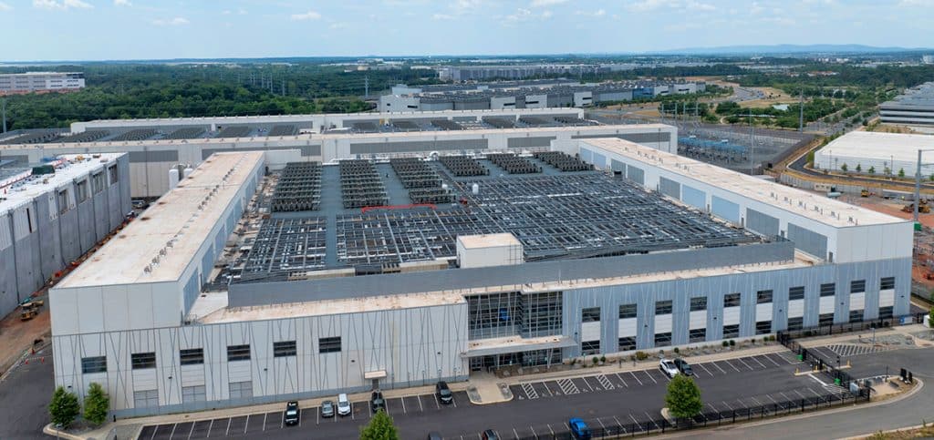 Aerial view of a large-scale data center, a key client for National Storage Tank's water storage solutions, showcasing the facility's extensive rooftop cooling infrastructure and surrounding industrial complex.