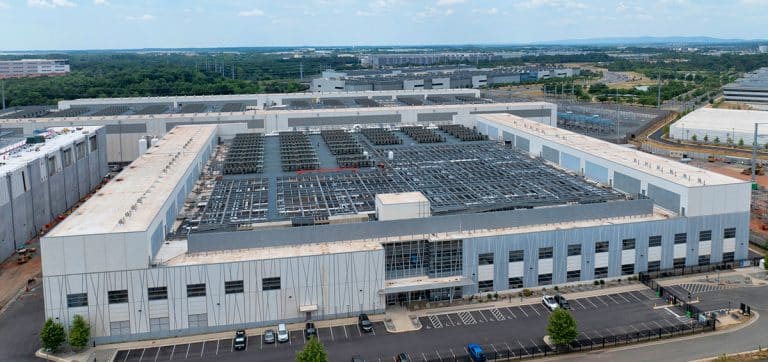 Aerial view of a large-scale data center, a key client for National Storage Tank's water storage solutions, showcasing the facility's extensive rooftop cooling infrastructure and surrounding industrial complex.