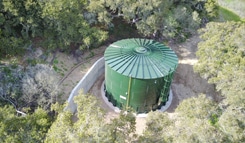 Green agricultural water storage tank installed at a winery for vineyard irrigation and fire protection systems.